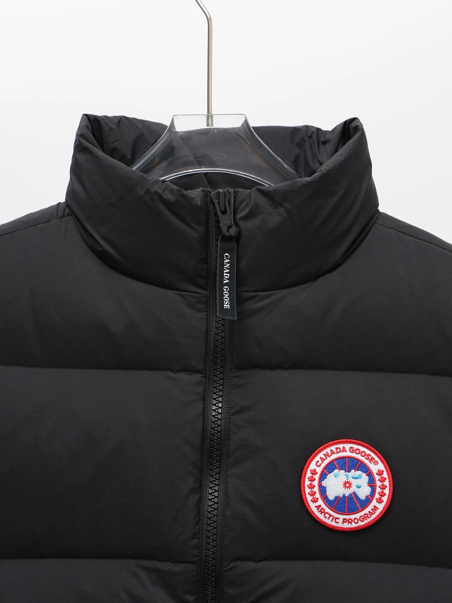 P580 Canada gooes Lawrence Down Vest (high version) With a durable shell and quilted body, the Lawrence Down Vest is a must-have for all seasons. The fabric has a durable soft touch. Longer hem at back for added protection. Reflective double-stripe grip tape at back. The Lawrence features an engineered down-filled collar to block strong winds, a two-way front zip and a longer rear hem. Color: black with red label, black with black label, desert color, ocean blue Size: XS -2XL